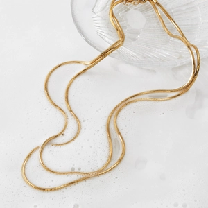 Double-layered gold flat snake chain necklace with a sleek minimalist polished finish