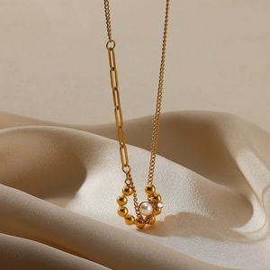Close-up of 18K gold stainless steel heart pendant with pearl on silk background