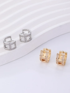 Close-up of gold and silver plated H-shaped earrings with micro-set white cubic zirconia