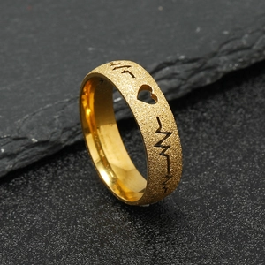 Detail of gold frosted stainless steel ring featuring cutout heart and EKG line patterns