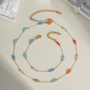 Detail of gold stainless steel necklace set with multi-colored faceted crystal beads