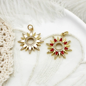 Detail of sunflower charms with red and white enamel in a ceramic dish with feathers