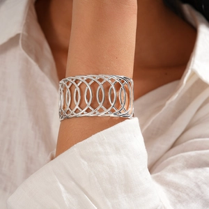 Vue détaillée d'un bracelet manchette ajouré argenté au design géométrique entrelacé