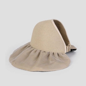 Detail of beige wide-brim sun hat showing straw weave and pleated fabric texture