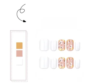 Close-up of white floral press-on nails with gold foil accents and nude pink base