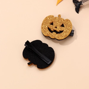 Macro view of Halloween pumpkin hair clip showing gold glitter front and metal alligator clip