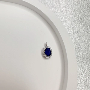 Oval blue sapphire pendant with diamond halo set in S925 silver on a white display tray
