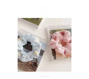 Close-up of pleated scrunchies in blue and pink with 3D rose flower floral details
