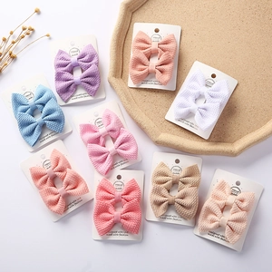 Detail of multi-color waffle fabric bow hair clips on display cards in macaron tones