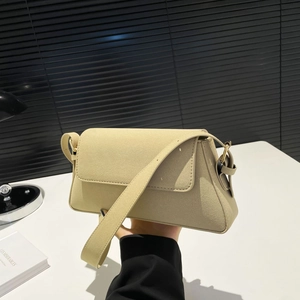 Detail view of the beige suede shoulder bag with gold metal buckle and wide strap