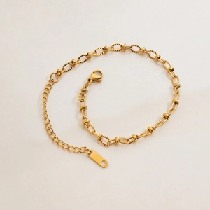Detail view of gold-plated flat oval link chain bracelet with lobster clasp and extender