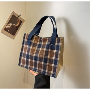 Detail of blue and brown checkered tote bag with durable woven canvas side panels