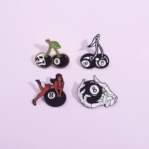 Set of four punk enamel pins featuring black 8 billiard balls, skulls, and bikini girls
