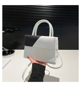 Détail du motif crocodile noir et blanc sur un sac à main structuré avec poignée