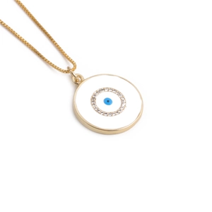 Detailed macro of gold plated Evil Eye pendant with white enamel and blue zircon stones