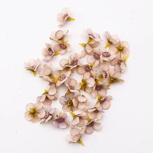 Macro shot of 2cm silk daisy heads in beige pink for DIY crafts and wedding decor