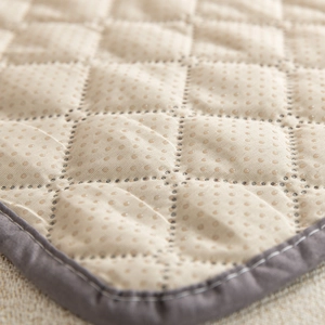Waterproof quilted pet bed mat in beige with anti-slip silicone dot backing and piping