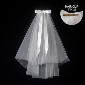 Detailed view of bridal veil with white satin bow and secure metal hair clip attachment