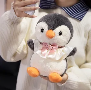 Detail of penguin plush toy with white frill collar and pink silk pearl bow decoration