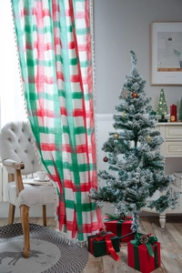 Detail of red and green plaid curtain featuring white tassel fringe and cotton-linen texture