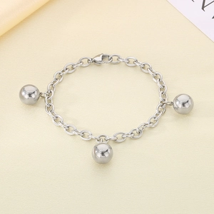 Close-up of silver steel chain bracelet featuring three polished round bead charms