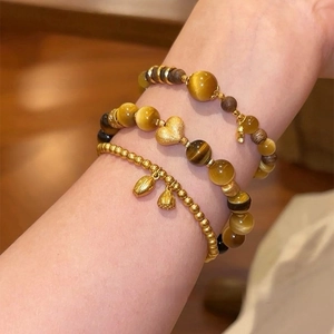 Dreiteiliges Vintage-Armbandset mit vergoldetem Tigerauge und Herz- sowie Lotosanhängern