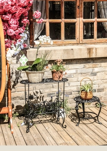 Detailansicht der schwarzen Eisen-Blumenständer mit Retro-Blumenmuster im Garten-Dekor