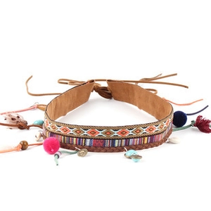 Detail of bohemian hemp rope hat accessory with embroidery, pink pom-poms and feathers