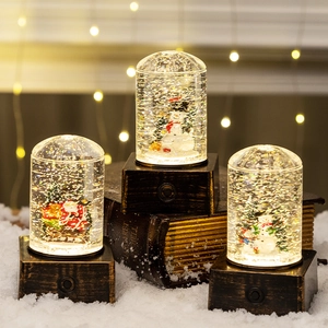 Three Christmas crystal ball lanterns with Santa and snowman scenes on vintage wood bases