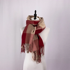 Detail of red and khaki plaid scarf featuring soft fringe and thick woven texture