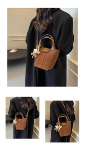Detailansicht der dunkelbraunen Eimer-Tasche aus Wildleder mit Bären-Anhänger