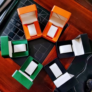 Bovenaanzicht van premium PU-lederen horlogedozen in oranje, groen en zwart met kussens