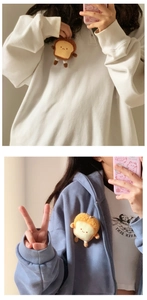 Cute plush toast charm used as a creative brooch on white and blue hoodies