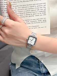 Close-up of a ladies' square silver watch with mesh strap and diamond hour markers