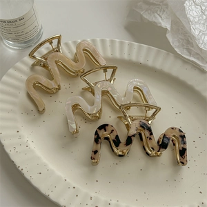 Elegant gold-plated wavy hair claws in cream, pearl white, and tortoiseshell patterns