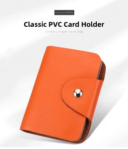 Macro detail of orange leather card holder with accordion slots and metal snap closure