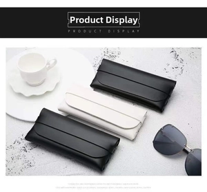Chic leather sunglass pouches in black and white arranged on a grey stone surface