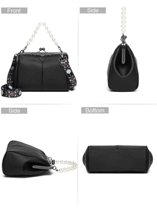 Detail view of black vintage clip bag with pearl handle and floral embroidered strap