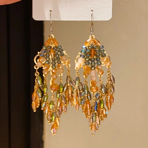 Detailed view of teardrop zircon earrings with multifaceted crystal glass beads and tassels