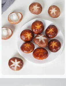Dettaglio di funghi shiitake realistici in PVC con tagli a stella su un piatto bianco
