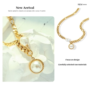 Detail of 18k gold plated figaro chain with large round pearl and irregular pendant