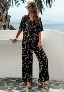 Detail shot of black two-piece set featuring abstract white lines and button-up shirt design