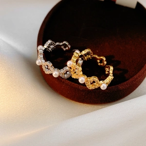 Détail de bagues en perles or 18k et argent avec zircon sur un plateau en velours