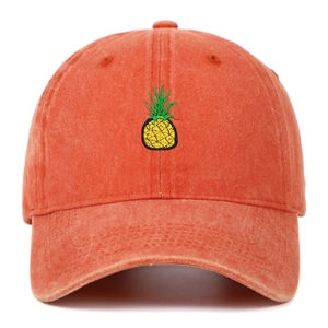 Close-up of embroidered pineapple on vintage washed orange cotton baseball cap