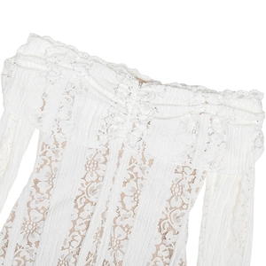 Detailed view of white floral lace fabric on an off-shoulder dress with elegant ruffles
