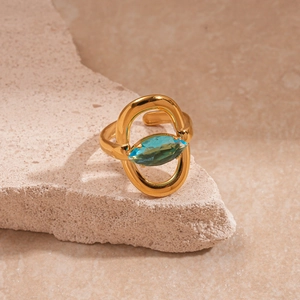 Détail d'une bague dorée vintage avec pierre précieuse cyan taille marquise sur pierre
