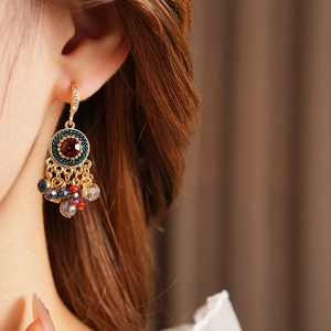 Detailansicht der Vintage-Ohrringe in Gold mit rotem Stein und blauen Webelementen