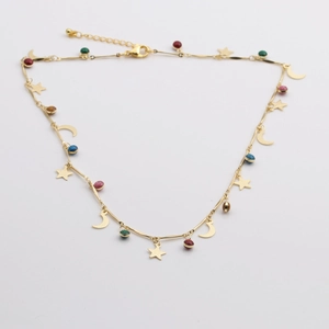 Détail de la chevillère dorée avec breloques étoile et lune et perles multicolores