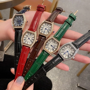 Multiple tonneau watches with leather straps and rhinestone bezel displayed on a hand