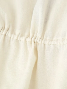 Detailed macro view of cream cotton-linen fabric with elastic gathered smocking details